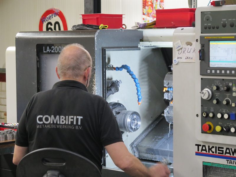 Operator van Combifit Metaalbewerking die een CNC-draaimachine bedient en metalen onderdelen bewerkt in de werkplaats.