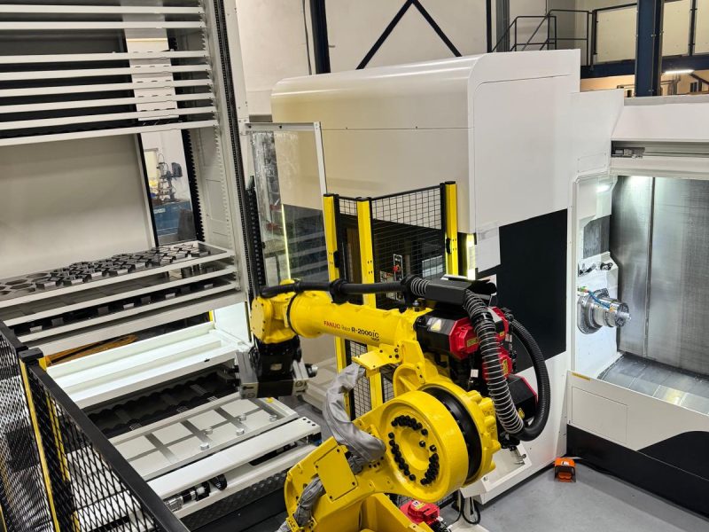 Geautomatiseerde CNC-machine met robotarm bij Combifit Metaalbewerking voor het laden en bewerken van metalen onderdelen.