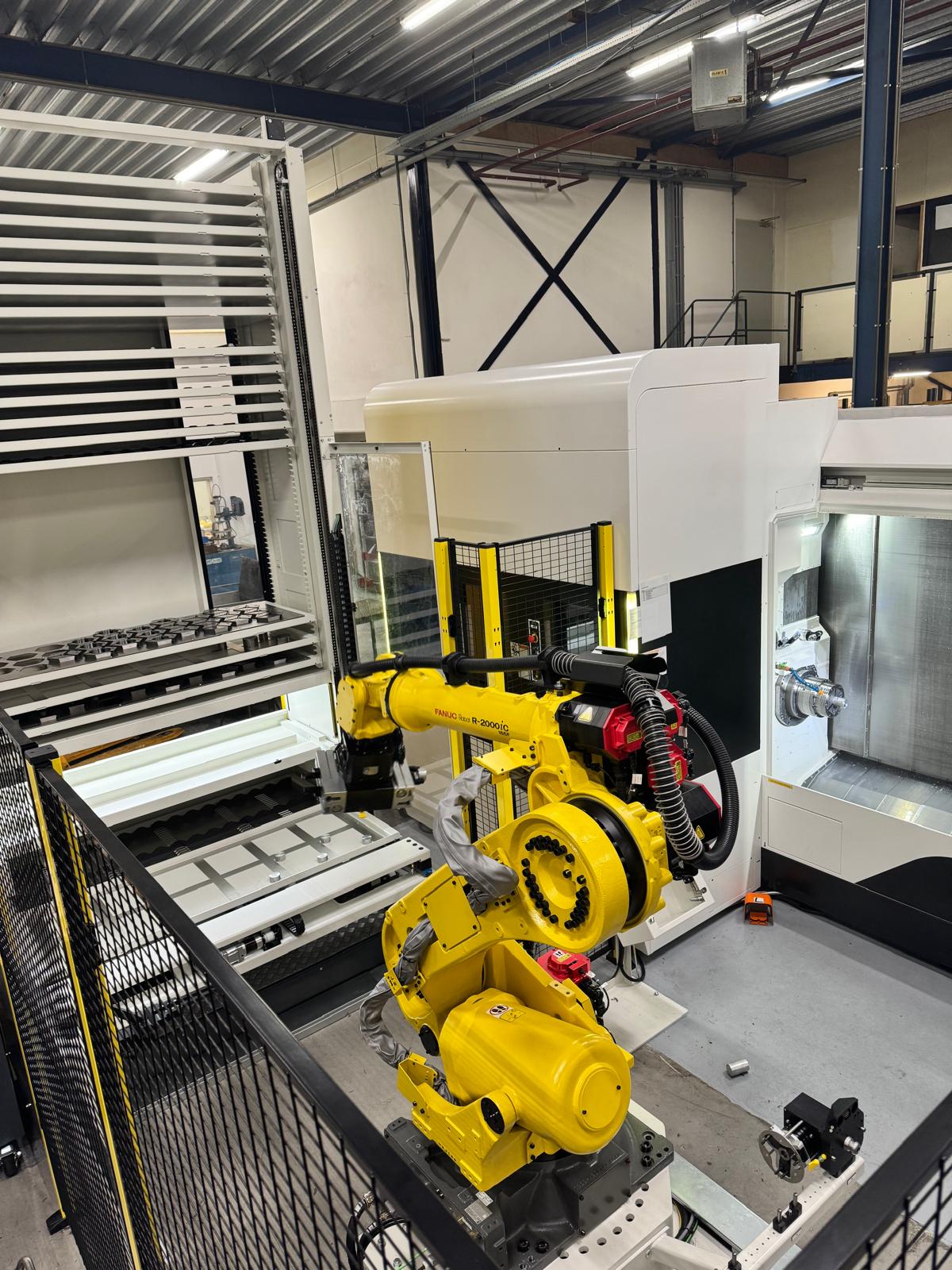 Geautomatiseerde CNC-machine met robotarm bij Combifit Metaalbewerking voor het laden en bewerken van metalen onderdelen.